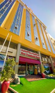 a yellow building with a new romantic hotel at Regal Peninsula Hotel Formerly New Peninsula Hotel Ghubaiba Bus Station Bur Dubai in Dubai