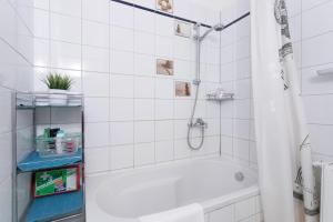 ein weißes Bad mit einer Badewanne und einer Dusche in der Unterkunft Central Garden Apartments in Wien