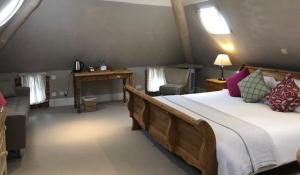 a bedroom with a large wooden bed and a desk at The Admiral Hornblower in Oakham