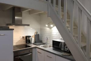a kitchen with a sink and a microwave at Gîte Ste Cécile plage in Camiers