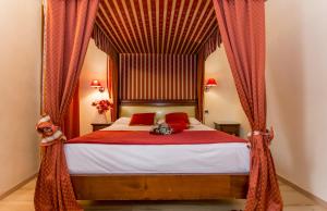 - une chambre avec un lit à baldaquin et des rideaux rouges dans l'établissement Residenza Rivo Alto, à Venise