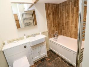 a bathroom with a sink and a tub and a mirror at Nana's Cottage in Camborne +19 photos