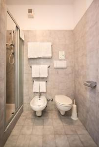 a bathroom with a toilet and a sink and towels at Hotel Astoria Gallarate in Gallarate