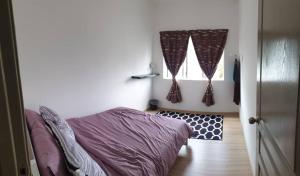 1 dormitorio con 1 cama y una ventana con cortinas en Chombies Muslim Homestay, en Tanah Rata