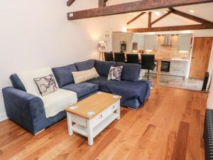 a living room with a blue couch and a table at Nana's Cottage in Camborne