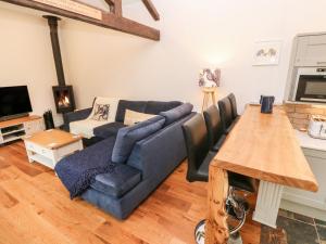 a living room with a blue couch and a table at Nana's Cottage in Camborne