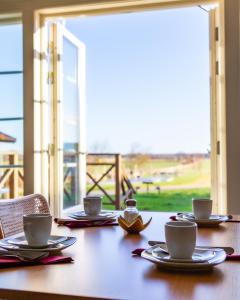 einen Tisch mit Tassen und Untertassen darüber in der Unterkunft Rödlix Vandrarhem & Camping in Tvååker