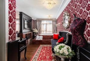 sala de estar con paredes rojas y blancas y sofá en Hotel Colline de France, en Gramado