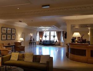 a living room filled with furniture and a large window at Sprowston Manor Hotel, Golf & Country Club in Norwich