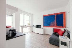 a living room with a couch and a painting on the wall at Mark's Gallery Apartment by MyHomeInComo in Como