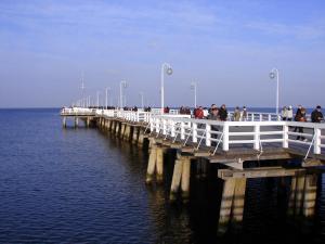 a group of people walking on a pier over the water at White Rock Apartment by Grand Apartments in Sopot