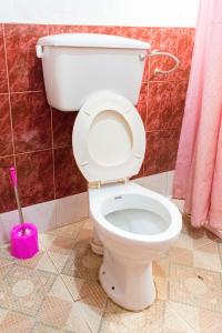 ein weißes WC im Bad mit einem rosafarbenen Stempel in der Unterkunft Jaguar Hotel Kampala in Kampala