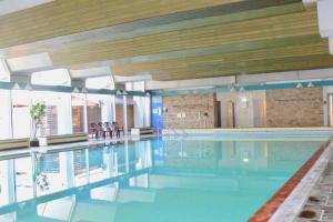 a large swimming pool with blue water in a building at Gaber in Bad Harzburg