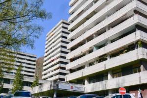 a tall white building with cars parked in front of it at Gaber in Bad Harzburg