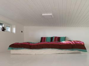 een bed in een witte kamer met afkeer bij Villa Gauja - Your Escape Near the Sea & Lakes in Pine Forest in Gauja