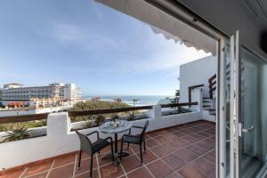 a balcony with a table and chairs and the beach at Villas Flamenco Beach Conil in Conil de la Frontera
