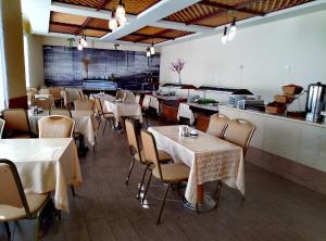 a restaurant with tables and chairs and a counter at Alex Resort & Spa Hotel in Gagra