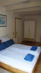 a bedroom with a large bed with blue towels on it at Gästehaus/FeWos/Boardinghaus Lüneburg Süd in Lüneburg