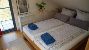 a bed with two blue towels on top of it at Gästehaus/FeWos/Boardinghaus Lüneburg Süd in Lüneburg