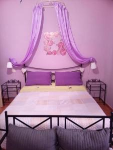 スポレートにあるDimora Spoletina Iのベッドルーム1室(紫色のカーテンと紫色の枕が備わるベッド1台付)