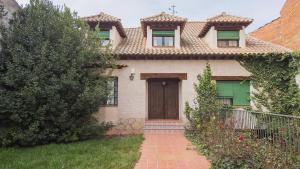 una casa con puerta marrón y entrada de ladrillo en Casa Virgen del Carmen (VUT), en La Mata