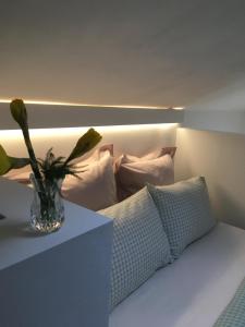 un jarrón de flores sentado en un sofá con almohadas en Passengers House en Whitstable