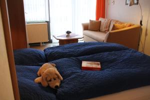 ヴィリンゲンにあるApartmenthaus Solinoの本を持ってベッドに寝た犬