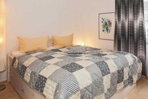 um quarto com uma cama com um edredão preto e branco em Villa Seestern Wohnung 9 em Neuhof