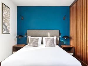 a bedroom with a large bed with a blue wall at Metropol Palace, Belgrade in Belgrade