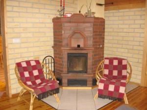 sala de estar con chimenea de ladrillo y 2 sillas en Holiday Home Niittylahti by Interhome, en Koro