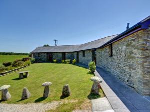 a stone house with stone statues in front of it at Holiday Home Travenna by Interhome in Saint Mawgan