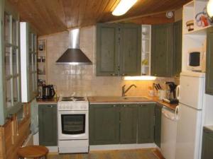 een keuken met groene kasten en een witte kookplaat bij Holiday Home Niittylahti by Interhome in Koro