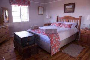 a bedroom with a bed with red pillows at Karoo Secret in Aberdeen
