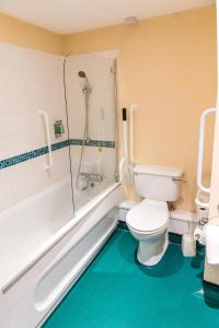 a bathroom with a toilet and a shower and a tub at Middle Aston House in Middle Aston