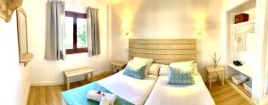 1 dormitorio con 1 cama con almohadas azules y blancas en Apartaments Sa Torre by SUREDA MAS, en Canyamel