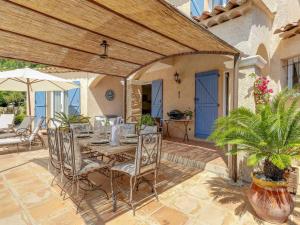 een patio met een tafel en stoelen en een parasol bij Holiday Home Villa Souleyas by Interhome in Sainte-Maxime