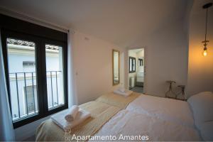 Un dormitorio con una cama y una ventana grande. en Apartamentos Plaza del Torico Teruel, en Teruel