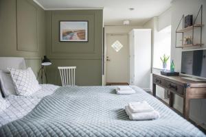 a bedroom with a bed with two towels on it at Värdshuset Lindgården in Visby