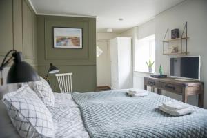 a bedroom with a bed with a desk and a television at Värdshuset Lindgården in Visby