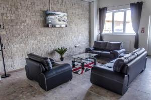 a living room with leather furniture and a table at Ubytovňa Milex in Nové Mesto nad Váhom