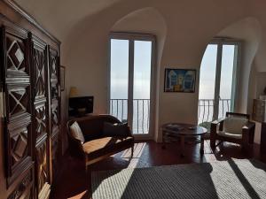 un soggiorno con divano e tavolo di Dans village médiéval piétonnier, Suite exécutive vue mer exceptionnelle a Roquebrune-Cap-Martin