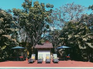 un groupe de chaises, de tables et de parasols dans l'établissement Hacienda Escondida 10min to Airport, à Alajuela