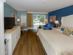 a bedroom with a bed, chair, and a window at Watkins Glen Harbor Hotel in Watkins Glen