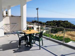 a table and chairs on a balcony with a view of the ocean at 4Seasons Sfakia in Khóra Sfakíon