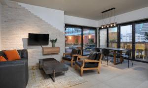 a living room with a couch and a table at Penthouse 3BR near Rothschild bd by HolyGuest in Tel Aviv