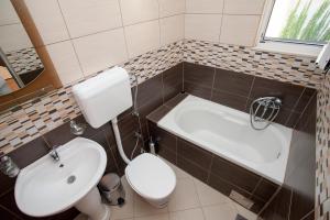 烏爾齊尼的住宿－Apartments Onyx，浴室配有卫生间、盥洗盆和浴缸。