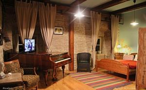 a bedroom with a piano and a bedroom with a bed at Auberge de Provence in Tuchoměřice
