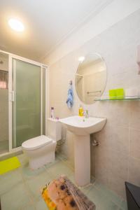 a bathroom with a sink and a toilet and a mirror at Esterina Suites in Nairobi