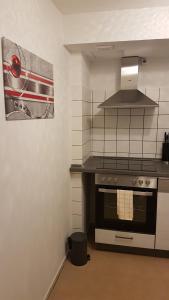a kitchen with a stove and a microwave at Ferienwohnung Sölden bei Freiburg im Breisgau in Sölden