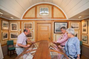 a group of people standing around a wooden table at Stor-Elvdal Hotell in Koppang